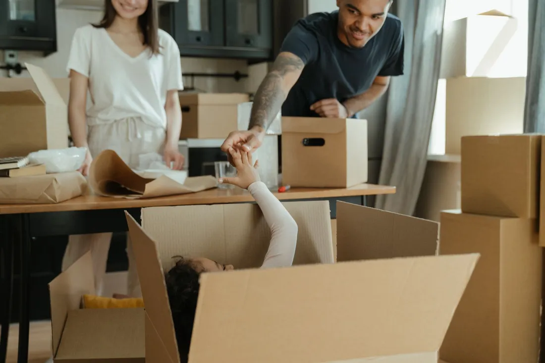 Umzugshelfer unterstützt eine Seniorin beim Packen